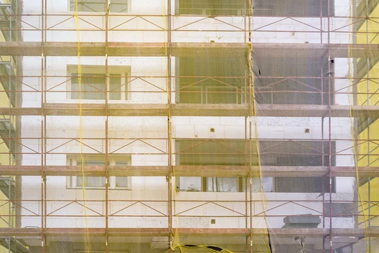 Chantier de construction d'immeuble résidentiel avec échafaudage métallique tubulaire sur façade